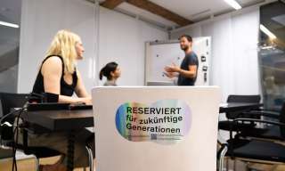 Eine Sitzungssituation mit einem Stuhl "Reserviert für zukünftige Generationen"
